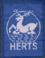 The Hertfordshire County badge, featuring a white Hart 