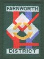 The design is a representation of the District. The white squares are Kearsley, Farnworth and Little Lever, the red lines the major roads and the blue representing the rivers and canal. The green background is the open space around the District and the gold circle links the three communities in Scouting.