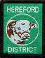 The Hereford District badge depicts the world famous red-brown and white Hereford Cattle.